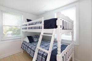 Only Steps 2 Ocean Couples Beach Retreat في فولي بيتش: غرفة نوم بها سريرين بطابقين ونافذة