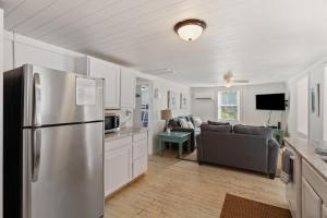 Only Steps 2 Ocean Couples Beach Retreat في فولي بيتش: مطبخ وغرفة معيشة مع ثلاجة ستانلس ستيل