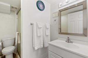 Only Steps 2 Ocean Couples Beach Retreat في فولي بيتش: حمام مع حوض ومرحاض ومرآة +24 صورة