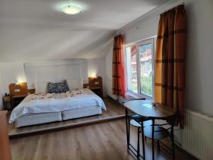 a bedroom with a bed and a table and a window at Guest House Lila in Bansko