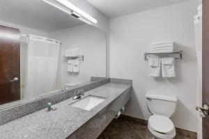 a bathroom with a sink and a toilet and a mirror at SureStay Hotel by Best Western Morganton in Morganton +20 photos