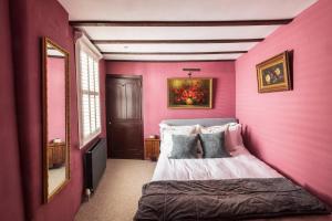 a bedroom with a pink wall with a bed in it at One Church Square in Rye