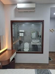 a bathroom with a glass window with a toilet and a sink at HOÀNG GIA LUXURy in Hanoi