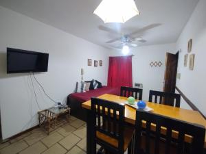 a room with a dining table and a bed and a television at Altos Mendoza Av España in Mendoza