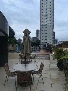 a table and chairs with an umbrella on a patio at Apartamento de Luxo in Belém