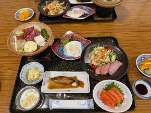 a table topped with plates of food on trays at Akaishi Ryokan in Fujikawaguchiko