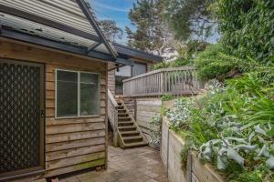 une maison en bois avec un escalier à côté d'un jardin dans l'établissement Little Tawny Studio - Private One Bedroom In Rye, à Rye