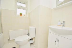 a white bathroom with a toilet and a sink at Spacious Central Oxford Detached Home in Oxford +30 photos