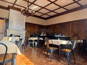 a dining room with tables and chairs and a fireplace at Travels Hotel in Osorno +17 photos