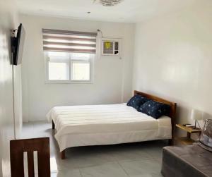 een witte slaapkamer met een bed en een raam bij Leribi Suites and Restaurant in Ulot +10 foto's