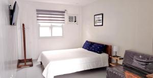 een witte slaapkamer met een bed en een raam bij Leribi Suites and Restaurant in Ulot