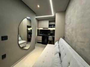 a living room with a couch and a mirror at Flat Luar Recanto Florah in Garanhuns