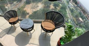 3 Stühle und ein Tisch auf dem Balkon in der Unterkunft Luxury Two Bedroom Apartment at NOVA Roman Ridge in Accra in Accra + 1 Foto