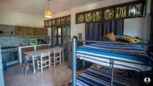 a bedroom with a bunk bed and a kitchen at Casa Mazunteña in Mazunte