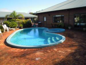 a large swimming pool on a brick patio at Tree Top Walk Motel in Walpole