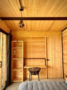 a wooden room with a bed and a chair in it at Taikú Ecolodge in Pacho