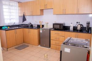 a kitchen with wooden cabinets and a refrigerator at The Monarch Suites in Lanet
