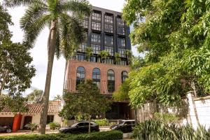 a building with palm trees in front of it at The Host Medellin in Medellín