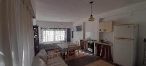 a kitchen with a couch and a table and a refrigerator at Pupe in San Clemente del Tuyú