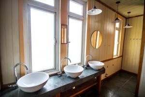 two sinks in a bathroom with two windows at 13 Lunas Hostel in Ancud +58 photos