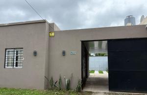a building with a blue door and a garage at Casa Apacheta in San Antonio de Areco