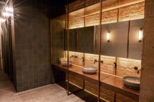 a bathroom with two sinks and two mirrors at The Host Medellin in Medellín +26 photos