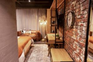 a room with a bed and a brick wall at The Host Medellin in Medellín