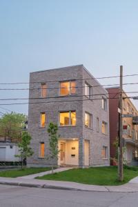 a gray brick building on a street corner at Le Madison Charmant et Unique 3 bedrooms in Quebec City