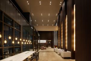 a lobby with a long table and chairs and lights at Shilla Stay Jeonju Hanok Village in Jeonju