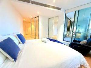 a bedroom with a white bed and a large window at Darling Harbor living - Sydney 2 beds condo pool in Sydney +27 photos