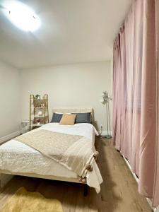 a bedroom with a bed and a pink curtain at Crystal's Place in Moncton