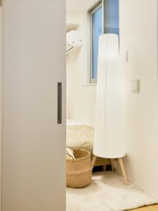a room with a white door and a basket at タスキsmart 錦糸町II in Tokyo