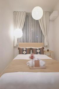 a bedroom with a white bed with two lights at タスキsmart 錦糸町II in Tokyo