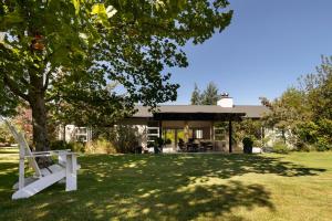 a white bench in front of a house at Arrowtown Home near Golf, Biking & Walking Trails in Motungarara