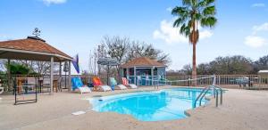 a swimming pool with chairs and a gazebo at Scenic 5-Acre Retreat with Hot Tub Pool & Game Room in Manor +83 photos