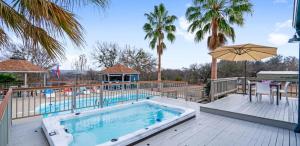 a swimming pool with an umbrella and a deck at Scenic 5-Acre Retreat with Hot Tub Pool & Game Room in Manor