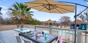 a patio with a table and an umbrella at Scenic 5-Acre Retreat with Hot Tub Pool & Game Room in Manor