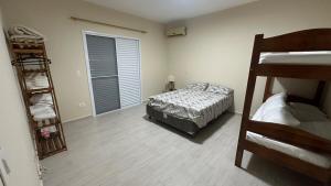 a bedroom with a bed and two bunk beds at Casa em Cananéia! in Cananéia +25 photos