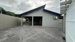 a white building with a blue roof and a patio at Casa em Cananéia! in Cananéia