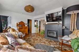 a living room with a couch and a fireplace at Chateau Gaine in New Plymouth