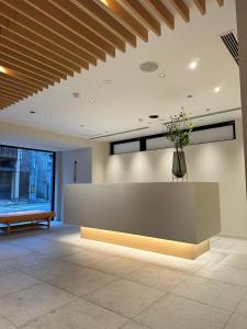 a lobby with a reception desk and a vase of flowers at KIORI Collection Shinmachi in Kyoto