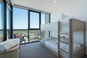 a bedroom with a bunk bed and large windows at Luxury Apartment on Franklin-3BD in Adelaide