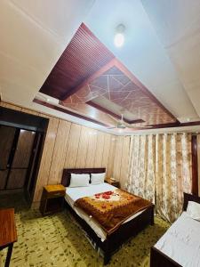 a bedroom with a bed in a room with a ceiling at travel and tour in Skardu