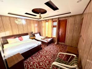 a bedroom with a bed and a chair in it at travel and tour in Skardu