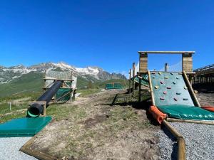 a playground with two slides on a hill with mountains at Appartement 6 pers aux pieds des pistes à Saint-François-Longchamp - FR-1-807-29 in Saint-François-Longchamp