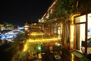 a house with lights on the side of it at night at Shuiyun Zhijian Homestay in Fenghuang