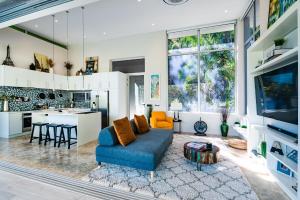 a living room with a blue couch and a kitchen at La Villetta in Ostional
