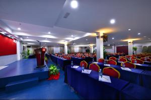 a room with blue tables and red chairs and a podium at Bahagia Hotel Langkawi in Kuah