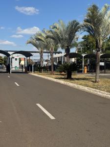 an empty road with palm trees and a building at Seminate Apartamento in Franca