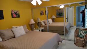 a bedroom with two beds and a mirror at Spectacular View Just Steps to Pool and Jacuzzi at Sunrise Country Club in Rancho Mirage